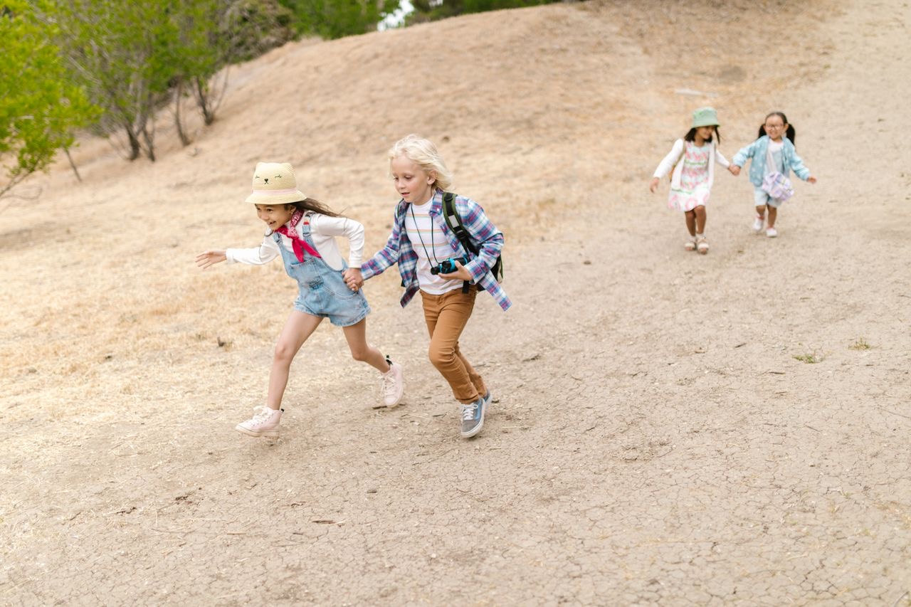 Children running together outdoors during a playful adventure